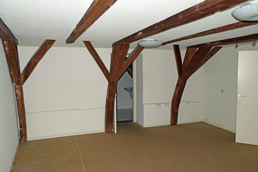 <p>Overzicht van de tweede verdieping in de richting van het voorhuis, met zicht op de onderste kapgebinten en de tussenhangbalken. Op enig moment zijn bij wijzigingen in dit bouwdeel de gebinten uit elkaar gehaald en in een andere volgorde herplaatst. </p>
